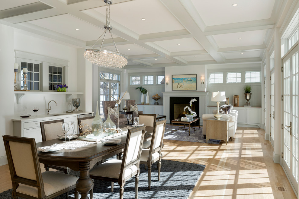 Exemple d'une salle à manger ouverte sur le salon bord de mer avec un mur blanc et parquet clair.