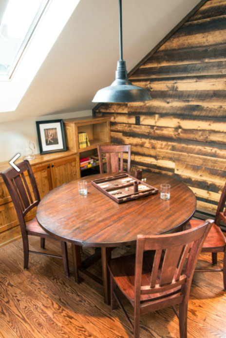 Cette photo montre une salle à manger ouverte sur le salon montagne avec un mur marron, un sol en bois brun, un poêle à bois, un manteau de cheminée en carrelage et un sol marron.