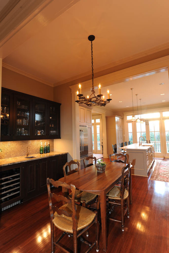 На фото: кухня-столовая среднего размера в классическом стиле с темным паркетным полом и бежевыми стенами без камина с