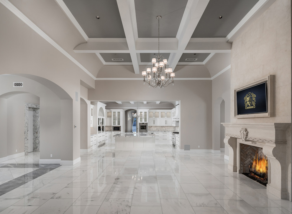 Immagine di un'ampia sala da pranzo moderna chiusa con pareti beige, pavimento in marmo, camino classico, cornice del camino in pietra e pavimento multicolore