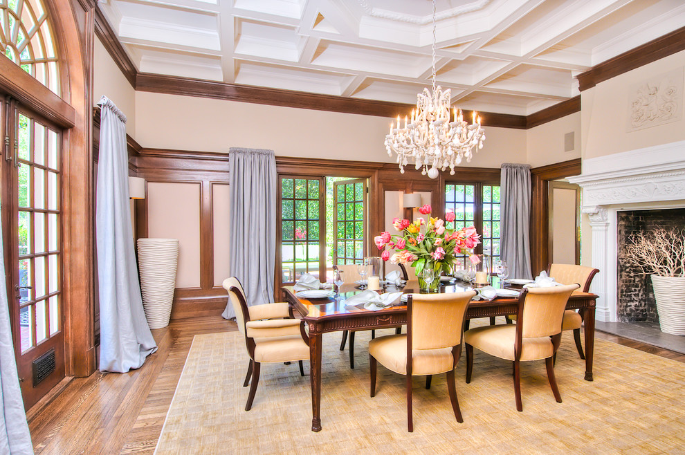Foto di una grande sala da pranzo classica chiusa con pareti beige, pavimento in legno massello medio e camino classico