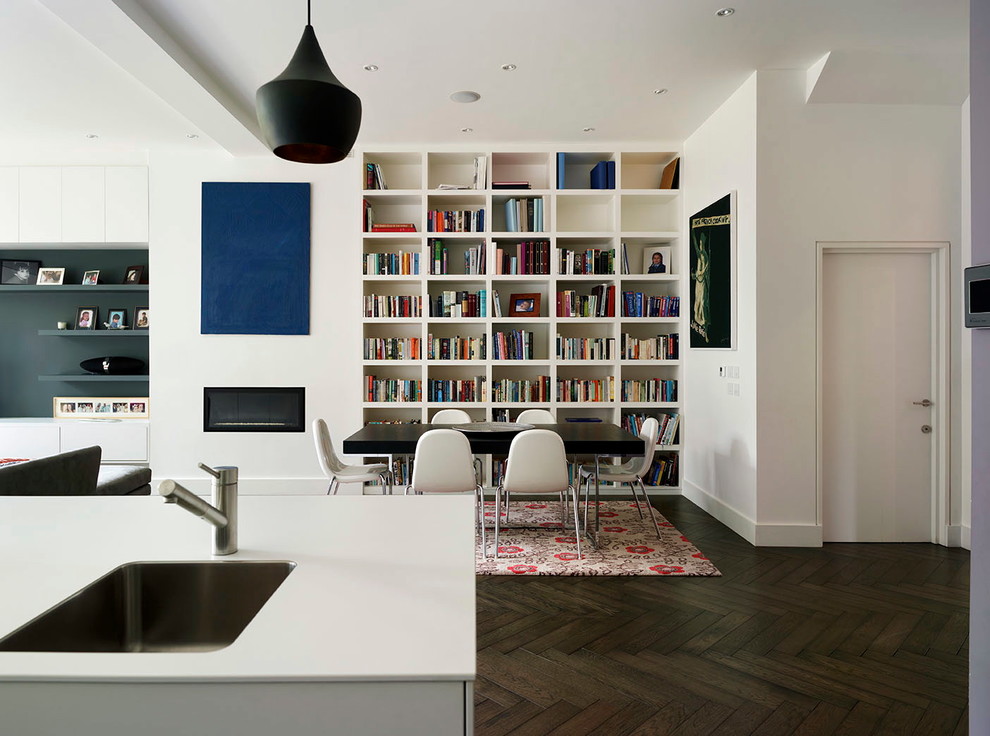 Diseño de comedor contemporáneo abierto con paredes blancas y suelo de madera oscura