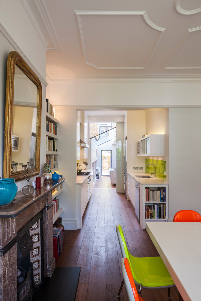 Immagine di una sala da pranzo aperta verso la cucina design con pareti bianche e pavimento in legno massello medio
