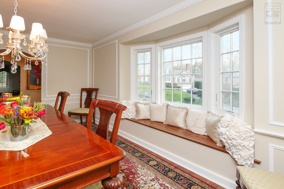 This is an example of a medium sized enclosed dining room in New York with beige walls, medium hardwood flooring, multi-coloured floors and wainscoting.