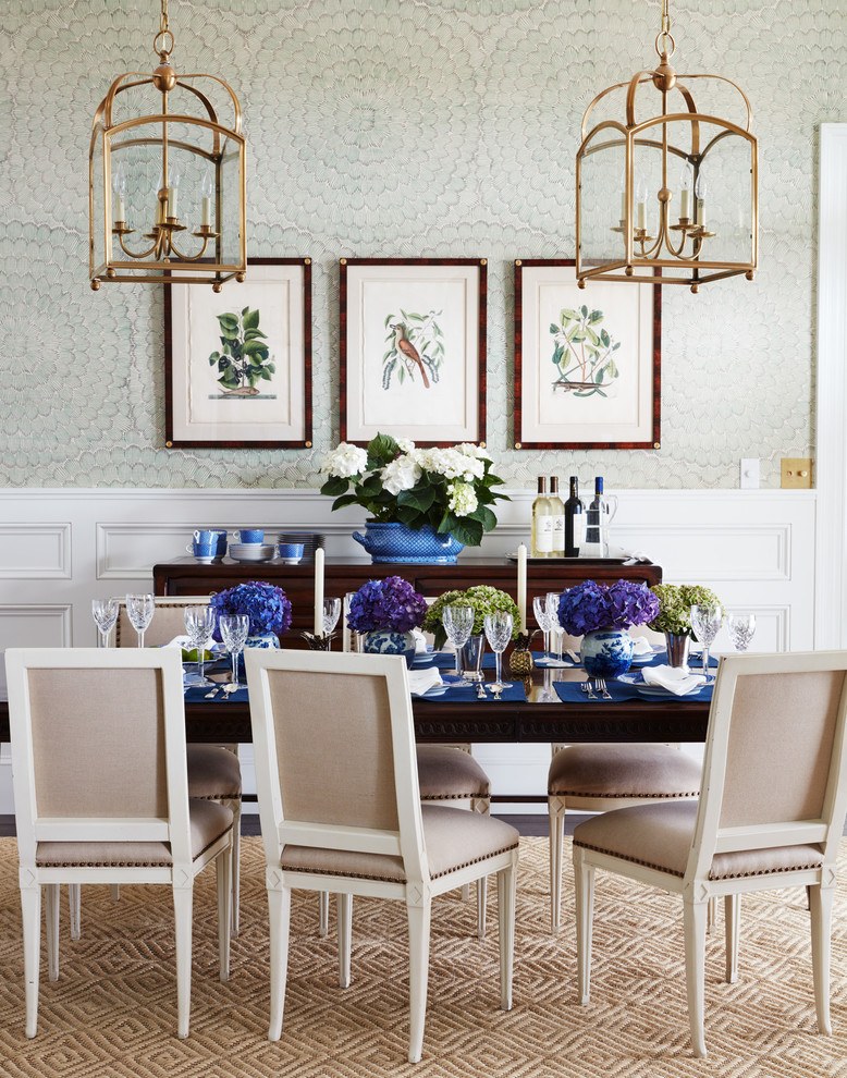Aménagement d'une grande salle à manger ouverte sur le salon classique avec un mur vert, parquet foncé et un sol marron.
