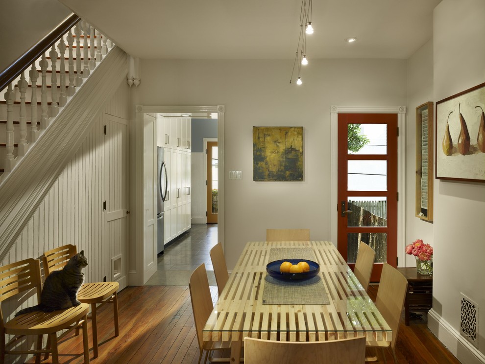Idées déco pour une salle à manger classique avec un mur blanc et un sol en bois brun.