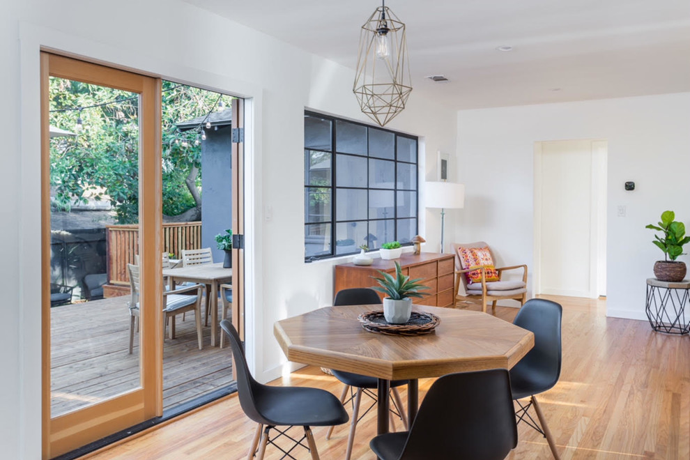Inspiration for a mid-sized mid-century modern light wood floor and brown floor enclosed dining room remodel in Los Angeles with white walls and no fireplace