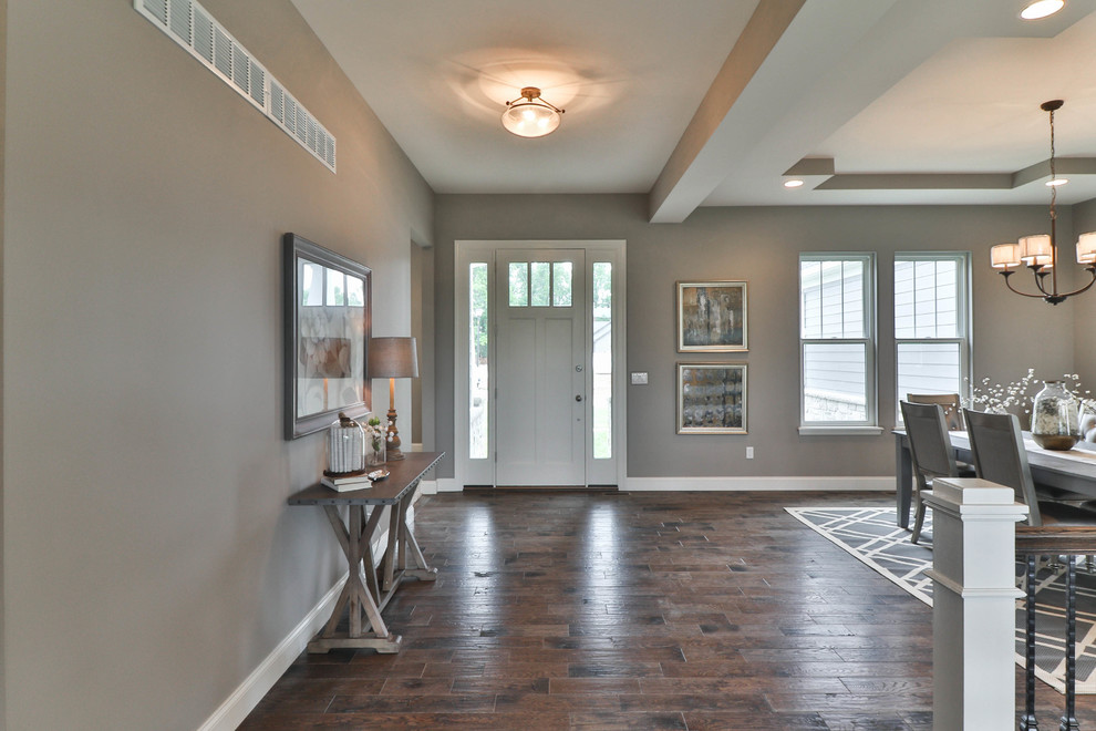 Example of a mid-sized transitional dark wood floor and brown floor great room design in St Louis with gray walls and no fireplace