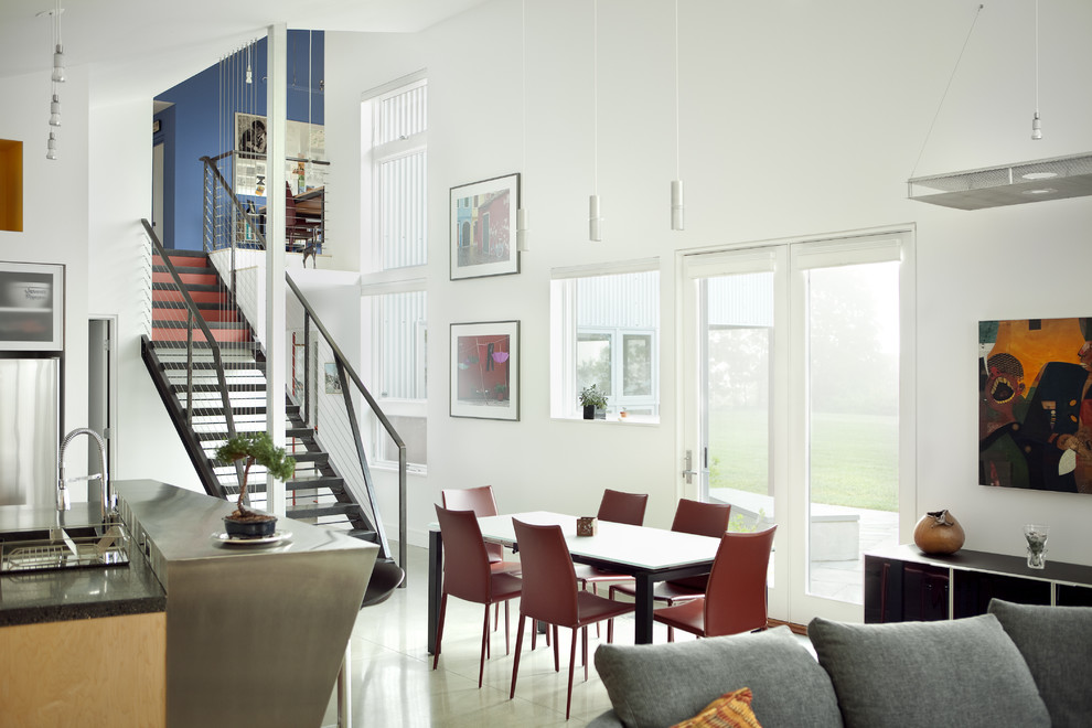 Immagine di una sala da pranzo aperta verso il soggiorno design con pareti bianche e pavimento in cemento