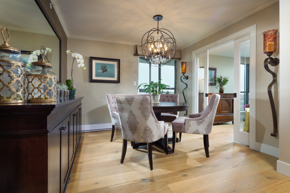 Medium sized modern enclosed dining room with beige walls and light hardwood flooring.