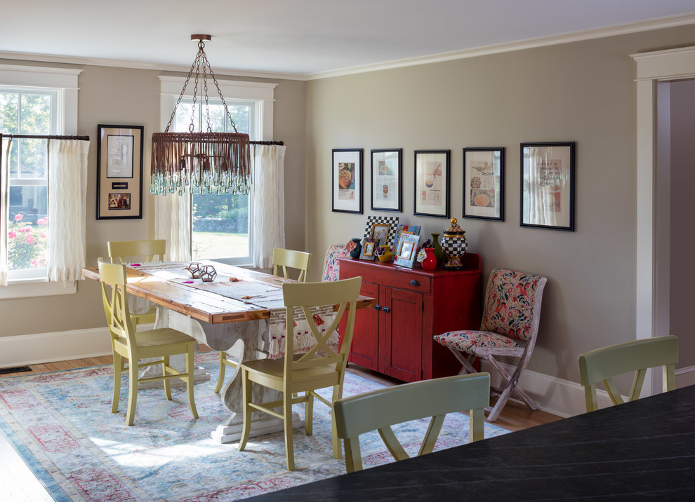 Foto di una sala da pranzo aperta verso la cucina country con pareti grigie e pavimento in legno massello medio