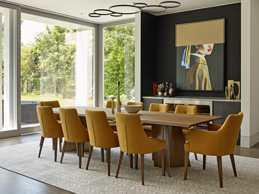 Cette image montre une salle à manger ouverte sur le salon design avec un mur blanc, un sol en bois brun, aucune cheminée et un sol marron.