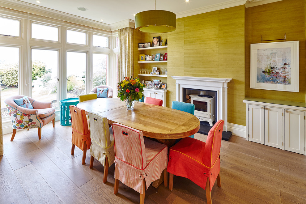 Photo of a classic dining room in Other with light hardwood flooring and a wood burning stove.