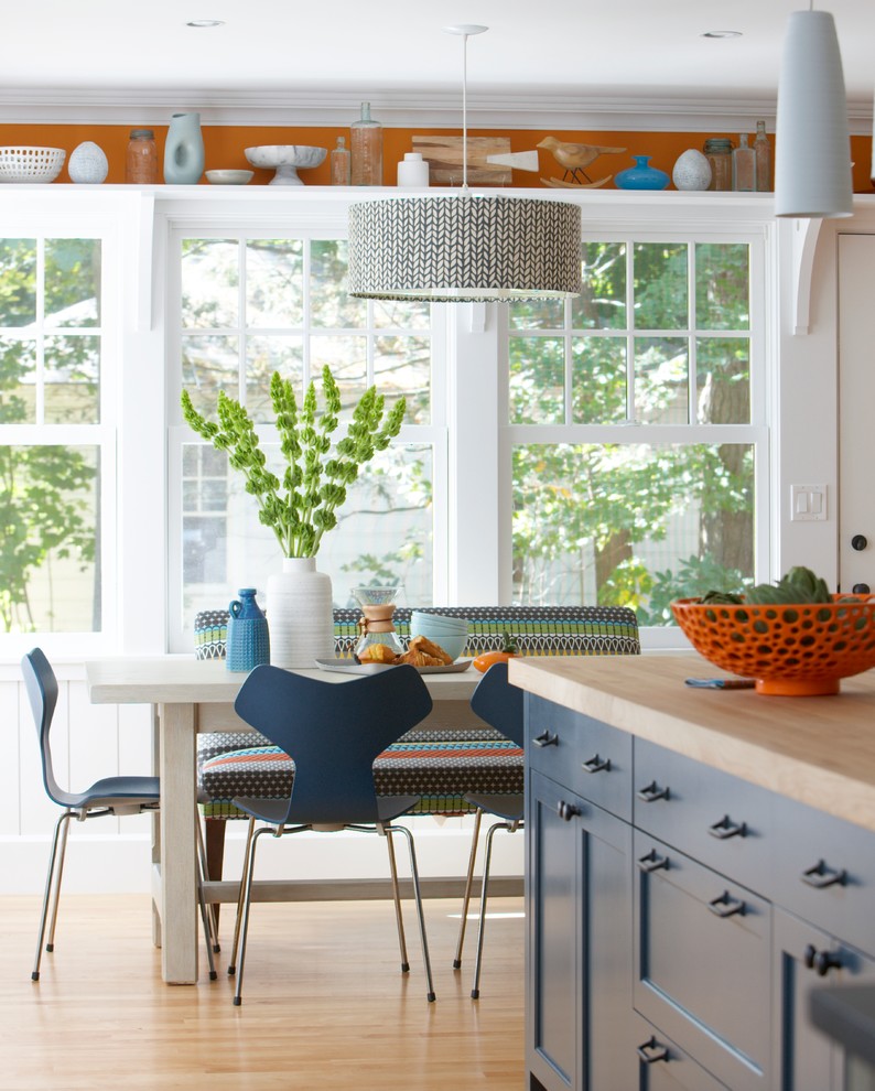 На фото: кухня-столовая в стиле неоклассика (современная классика) с белыми стенами и светлым паркетным полом без камина с