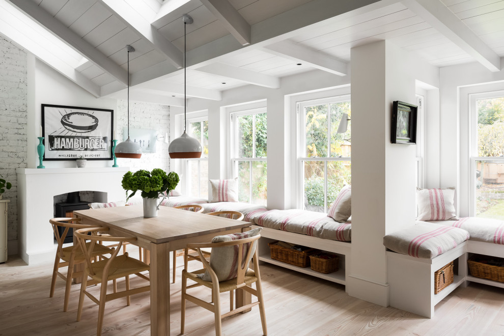 Große Landhaus Wohnküche mit weißer Wandfarbe, braunem Holzboden, Kamin, verputzter Kaminumrandung und beigem Boden in London