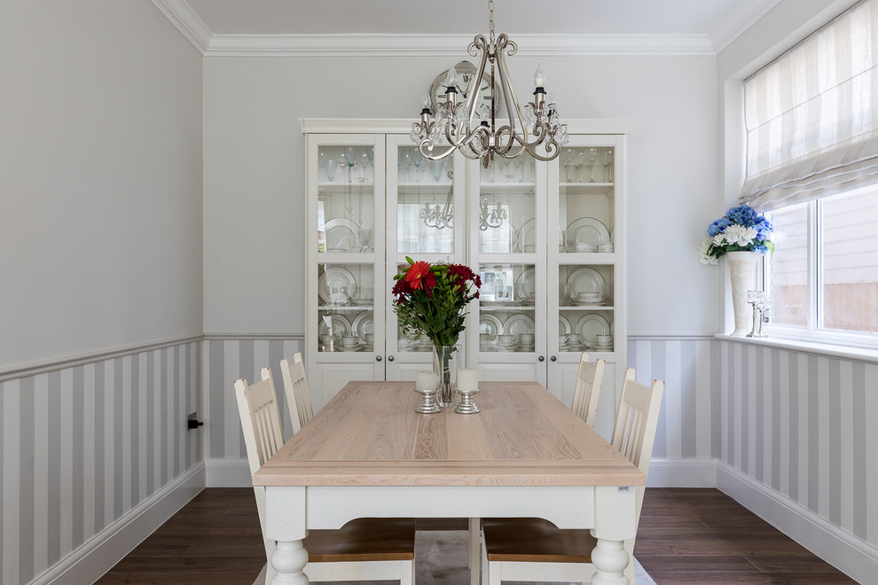 Photo of a small traditional enclosed dining room in London with grey walls, porcelain flooring, no fireplace and brown floors.