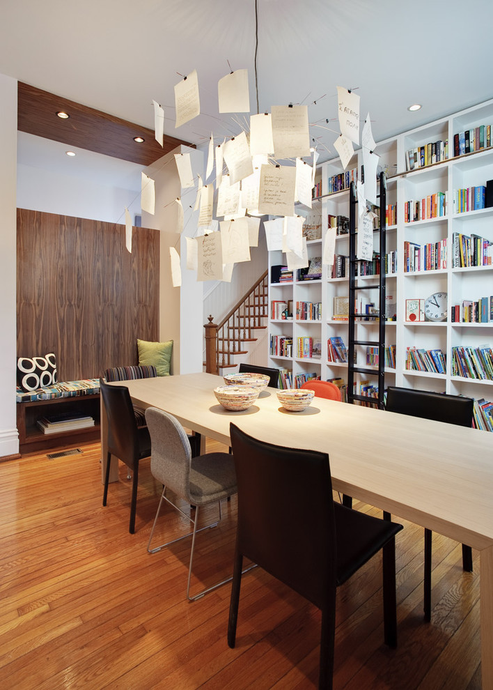 Imagen de comedor minimalista con paredes blancas y suelo de madera en tonos medios