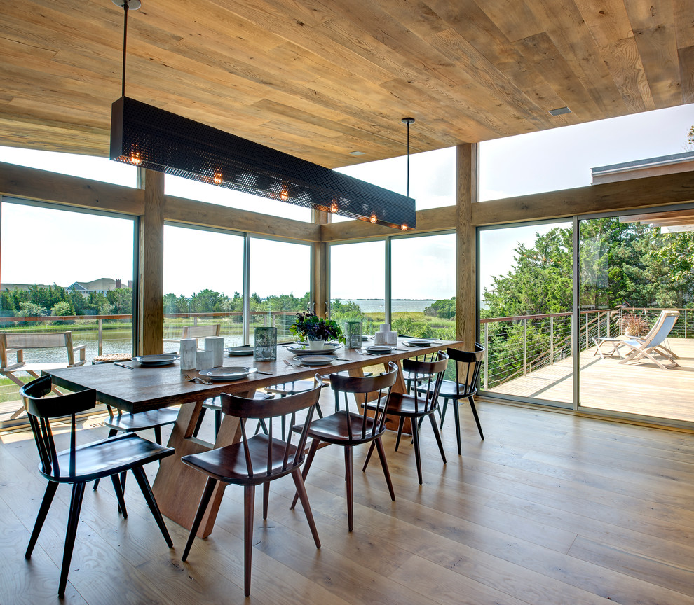 Aménagement d'une salle à manger contemporaine avec un sol en bois brun.