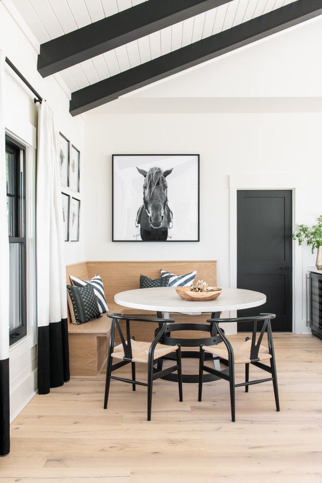 Diseño de comedor campestre con con oficina, paredes blancas, suelo de madera clara y vigas vistas