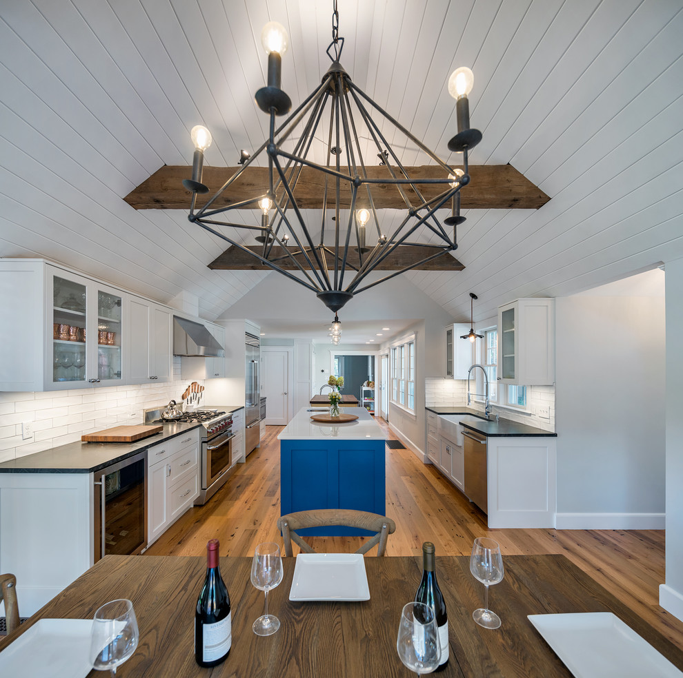Idées déco pour une salle à manger ouverte sur la cuisine campagne de taille moyenne avec un mur bleu et un sol en bois brun.