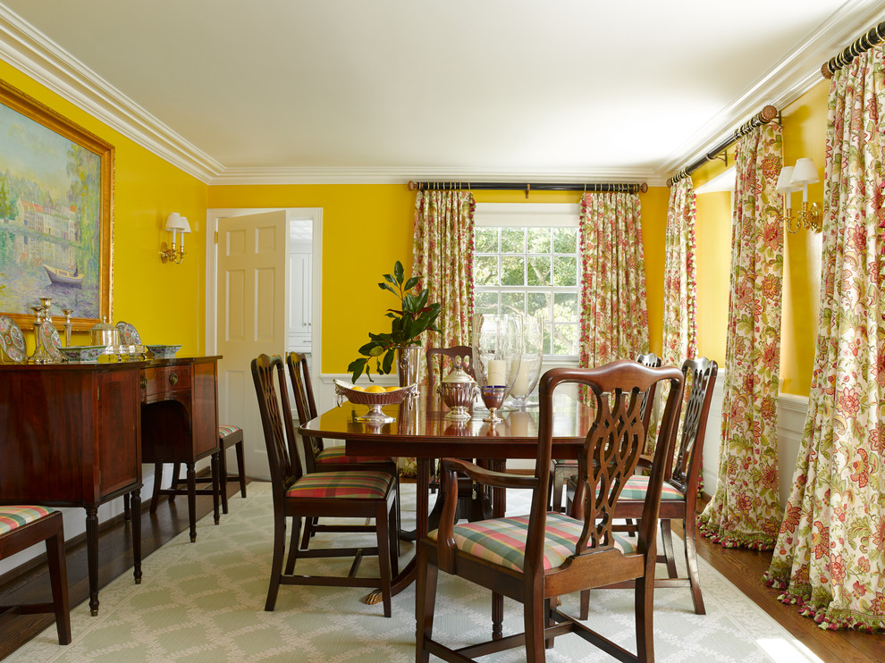 Immagine di una sala da pranzo tradizionale chiusa con pareti gialle e parquet scuro