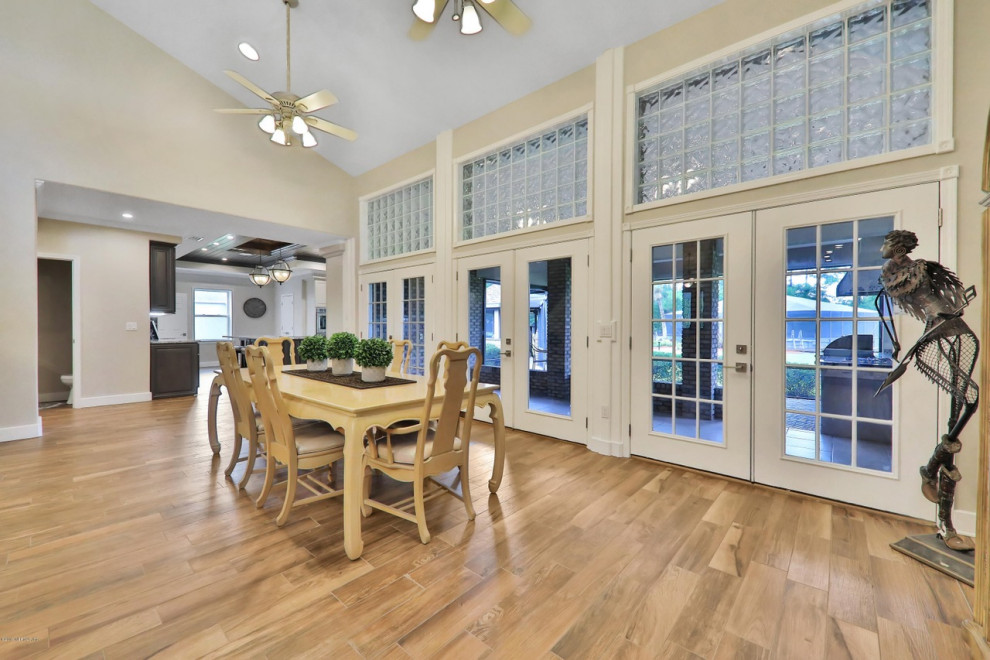 Photo of a large rural open plan dining room in Jacksonville with white walls, no fireplace, brown floors and ceramic flooring.