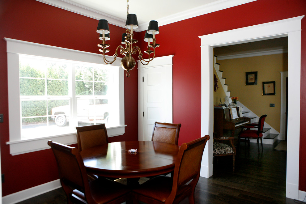 Example of a mid-sized farmhouse dark wood floor enclosed dining room design in Portland with red walls