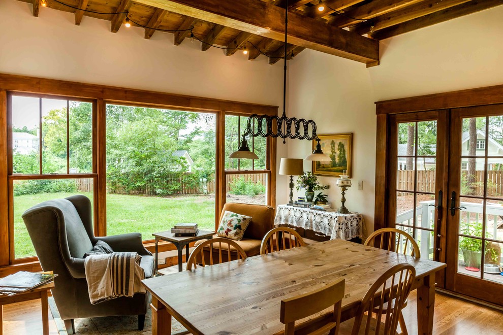 Idee per una sala da pranzo aperta verso la cucina country con pareti bianche e pavimento in legno massello medio
