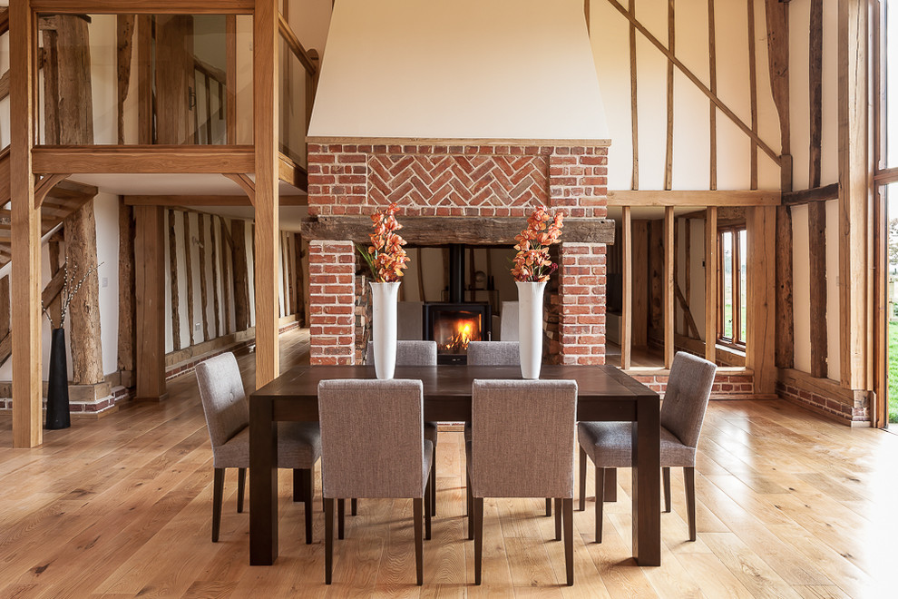 Design ideas for a country open plan dining room in London with beige walls and medium hardwood flooring.