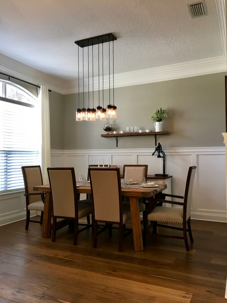 Inspiration for a mid-sized farmhouse medium tone wood floor enclosed dining room remodel in Jacksonville with gray walls