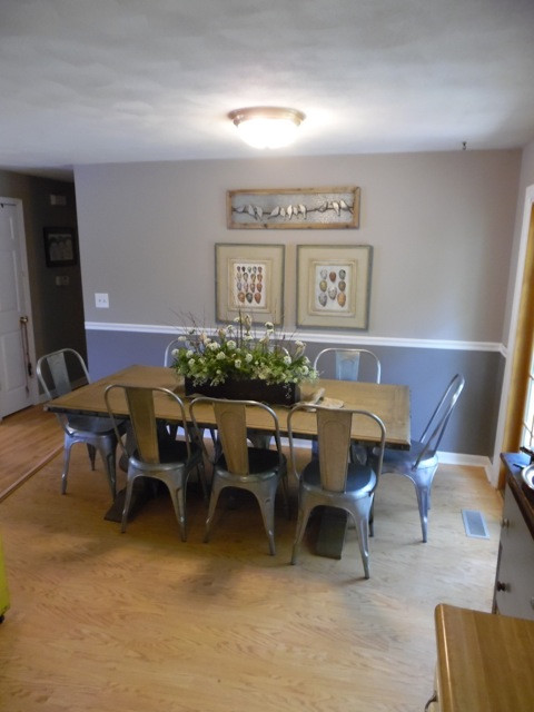 Cette photo montre une salle à manger ouverte sur la cuisine nature de taille moyenne avec un mur gris et un sol en bois brun.