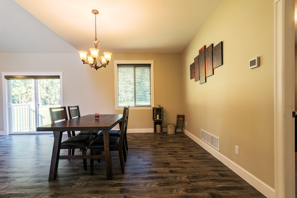 Cette image montre une petite salle à manger ouverte sur le salon traditionnelle avec un mur marron, sol en stratifié et un sol marron.