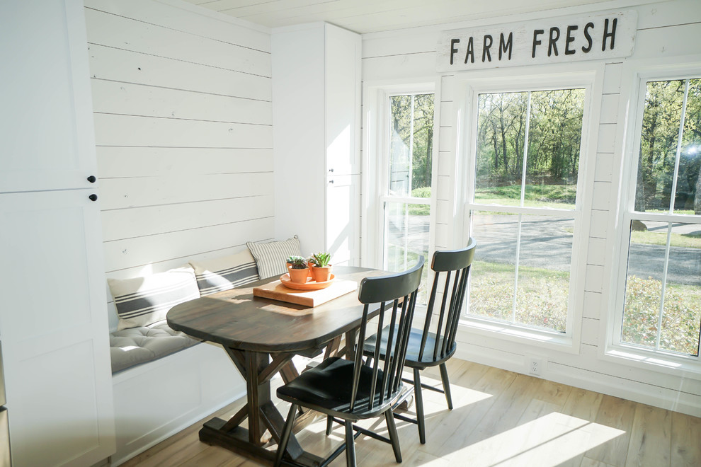 Immagine di una sala da pranzo aperta verso la cucina country con pareti bianche, pavimento in vinile e pavimento beige