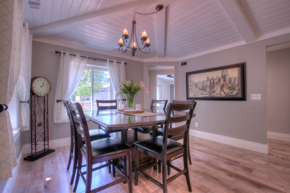 Réalisation d'une salle à manger ouverte sur la cuisine champêtre de taille moyenne avec un mur gris, un sol en bois brun, un sol gris et aucune cheminée.