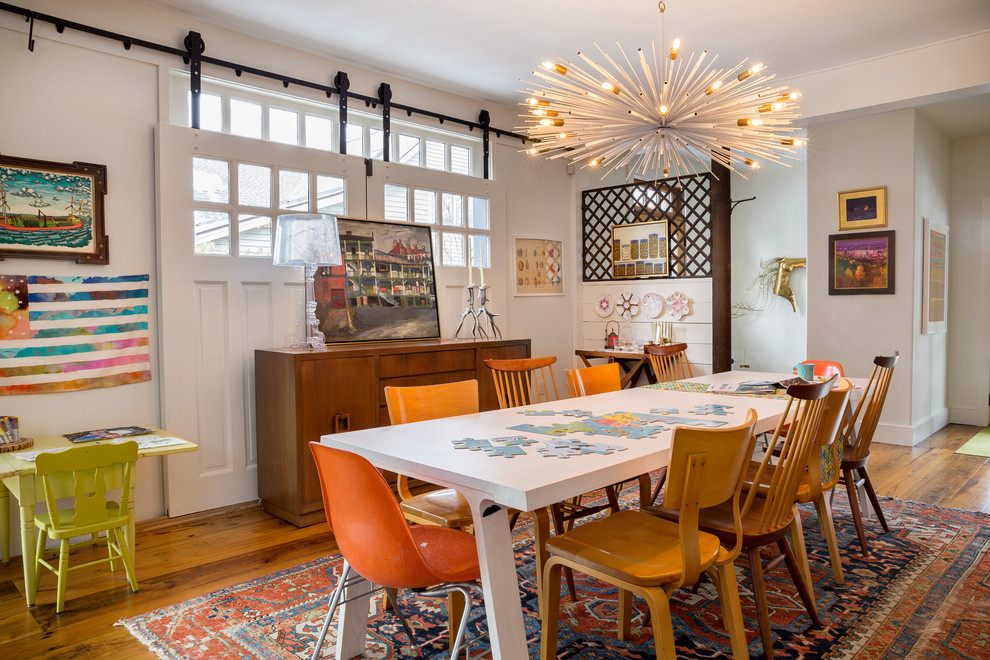 Cette photo montre une grande salle à manger ouverte sur la cuisine moderne avec un mur blanc, un sol en bois brun et un sol marron.