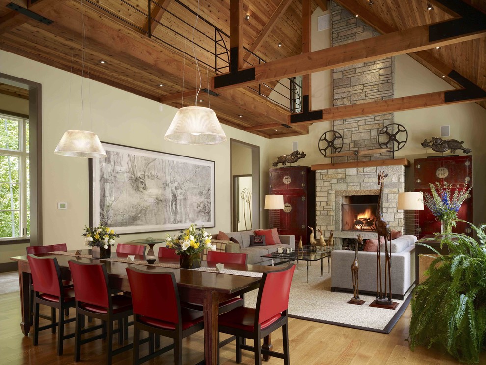Cette image montre une salle à manger ouverte sur le salon rustique avec un mur beige, un sol en bois brun et éclairage.