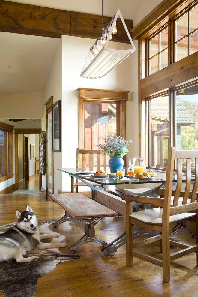 Inspiration pour une salle à manger chalet avec un mur blanc et un sol en bois brun.