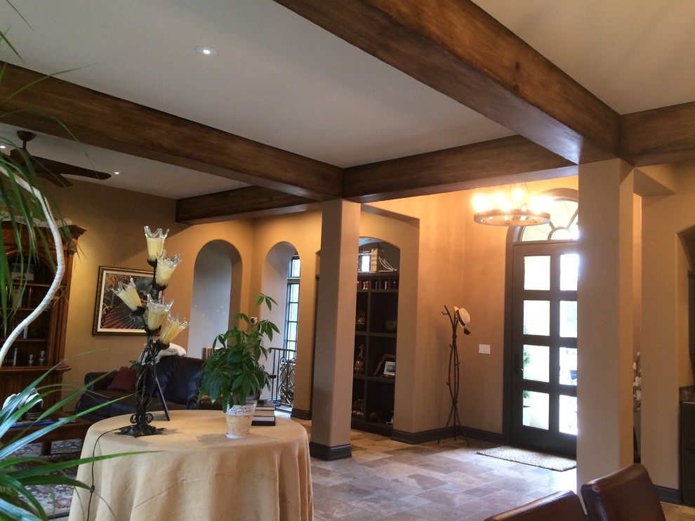 Foto di una grande sala da pranzo aperta verso il soggiorno rustica con pareti beige, pavimento in ardesia, camino classico e cornice del camino piastrellata