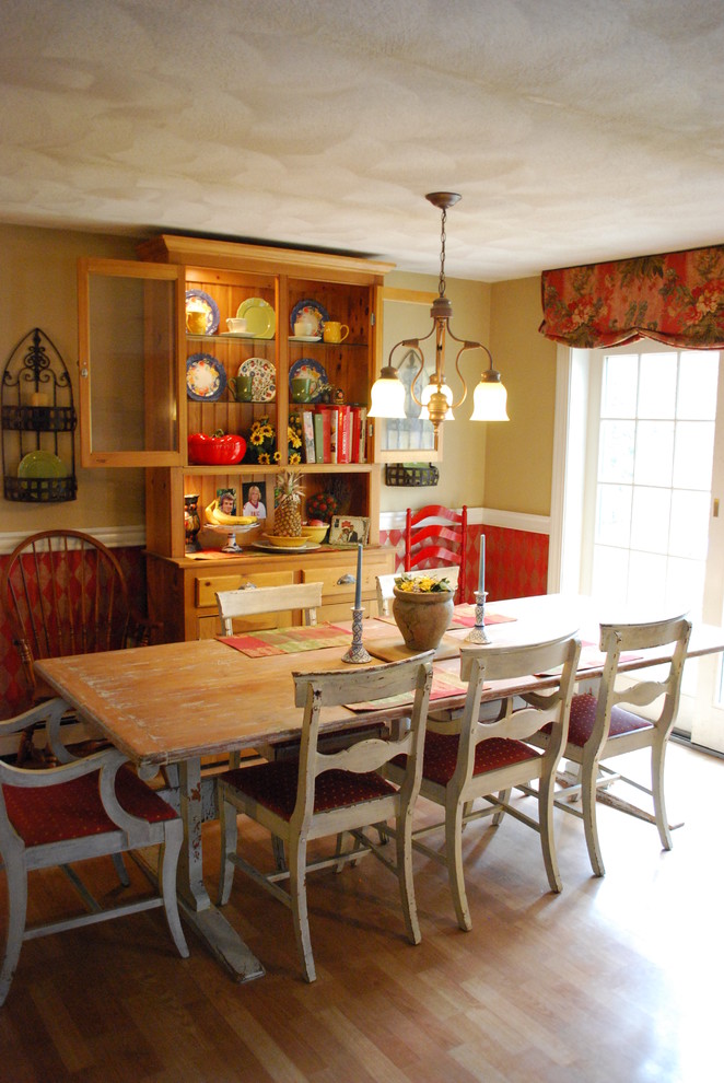 Immagine di una sala da pranzo country con pareti gialle e pavimento in legno massello medio