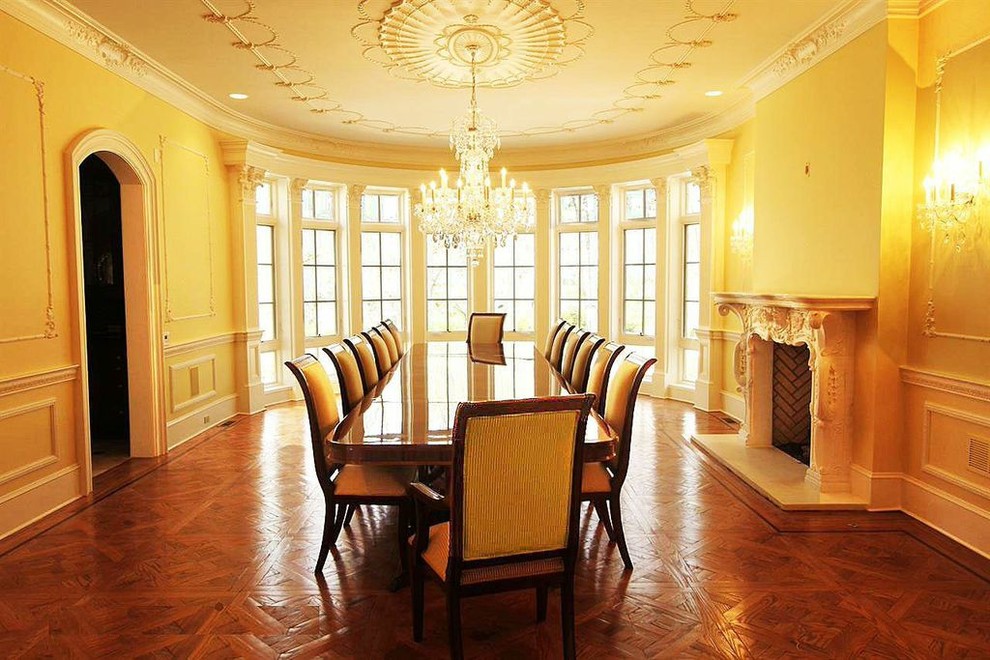 Exemple d'une très grande salle à manger ouverte sur la cuisine chic avec un mur bleu, parquet foncé, une cheminée standard et un manteau de cheminée en plâtre.