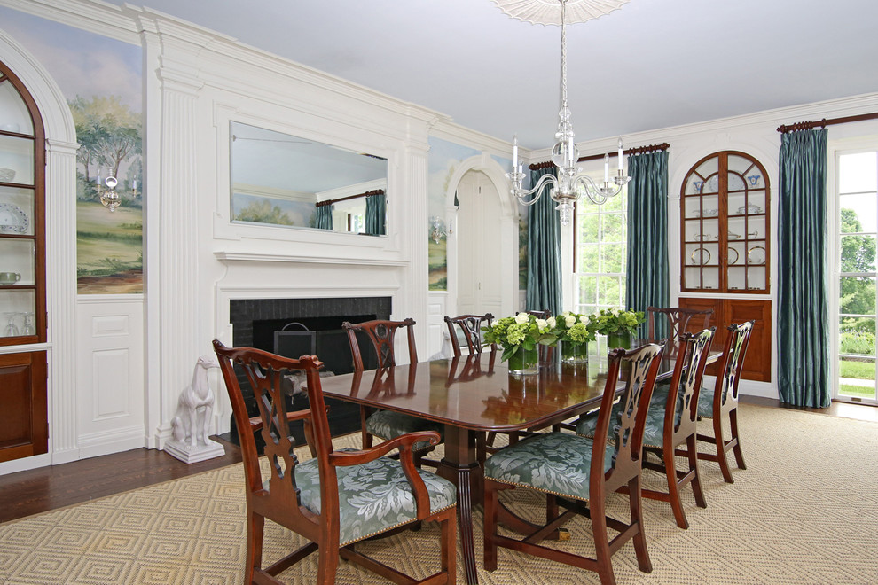 Example of a classic dark wood floor enclosed dining room design in Boston with white walls and a standard fireplace