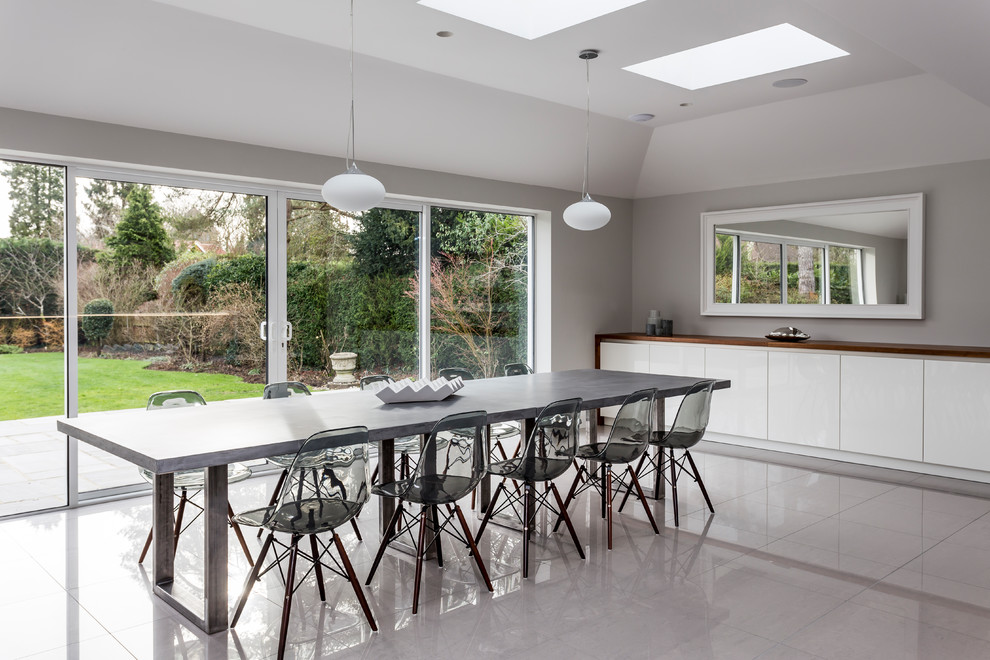 Idee per un'ampia sala da pranzo aperta verso la cucina design con pavimento in gres porcellanato, pavimento grigio e pareti grigie