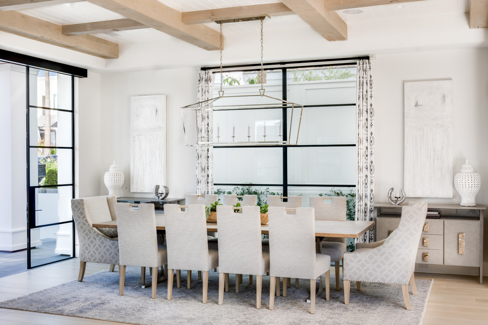 Immagine di una sala da pranzo stile marinaro con pareti bianche, parquet chiaro e nessun camino