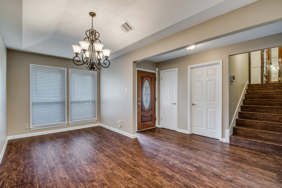 Klassische Wohnküche mit beiger Wandfarbe, Vinylboden, Kamin, Kaminumrandung aus Backstein und braunem Boden in Austin