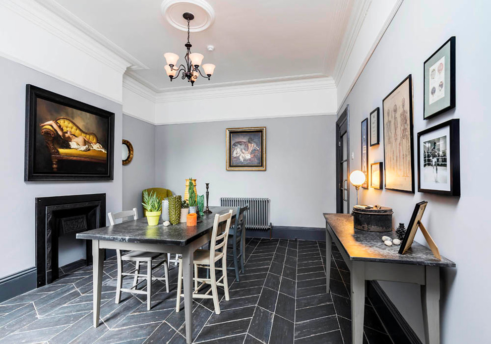 Idee per una sala da pranzo classica di medie dimensioni e chiusa con pareti grigie, camino classico e pavimento nero