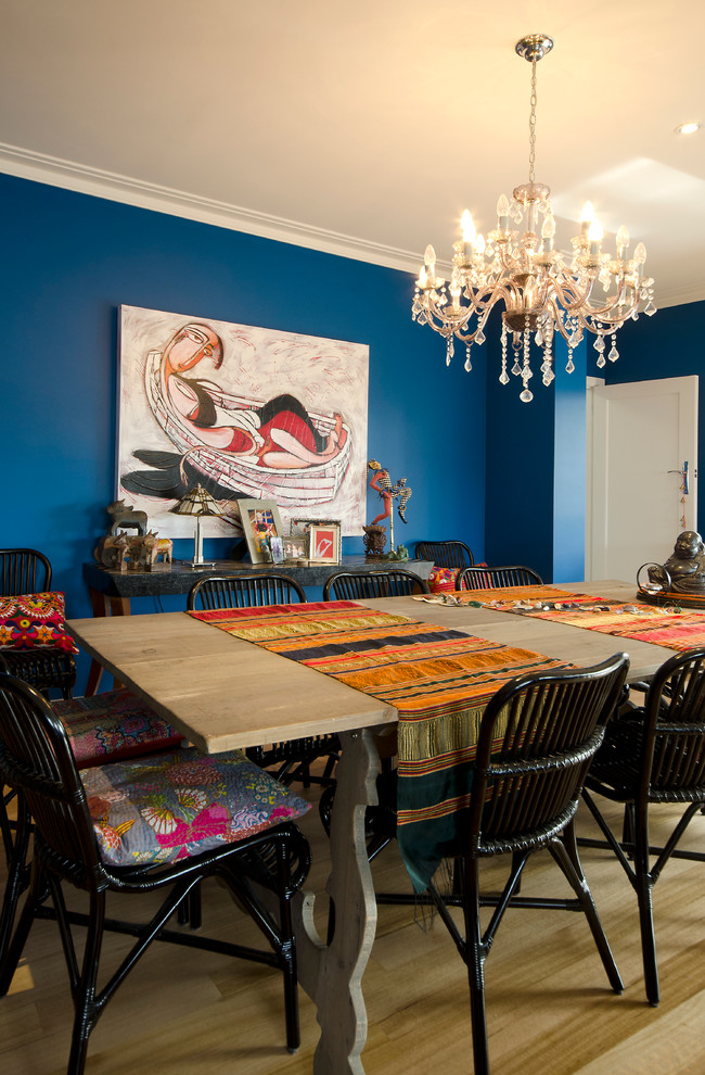 Ispirazione per una grande sala da pranzo aperta verso il soggiorno boho chic con pareti blu e pavimento in legno massello medio
