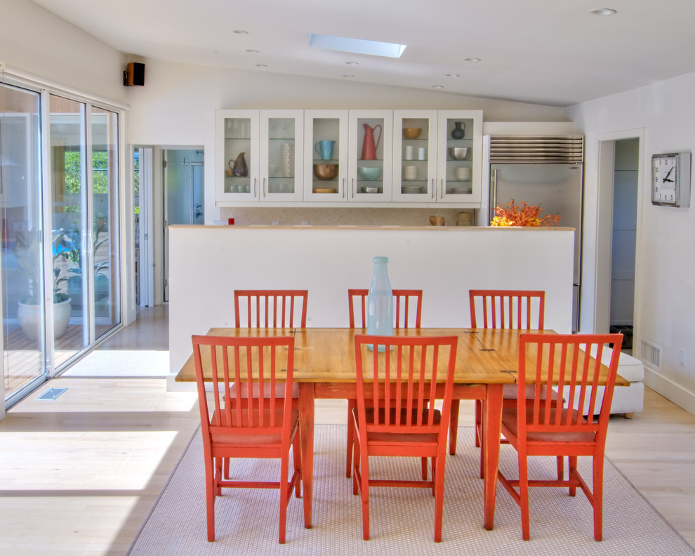 Esempio di una sala da pranzo aperta verso la cucina costiera con pareti bianche e parquet chiaro