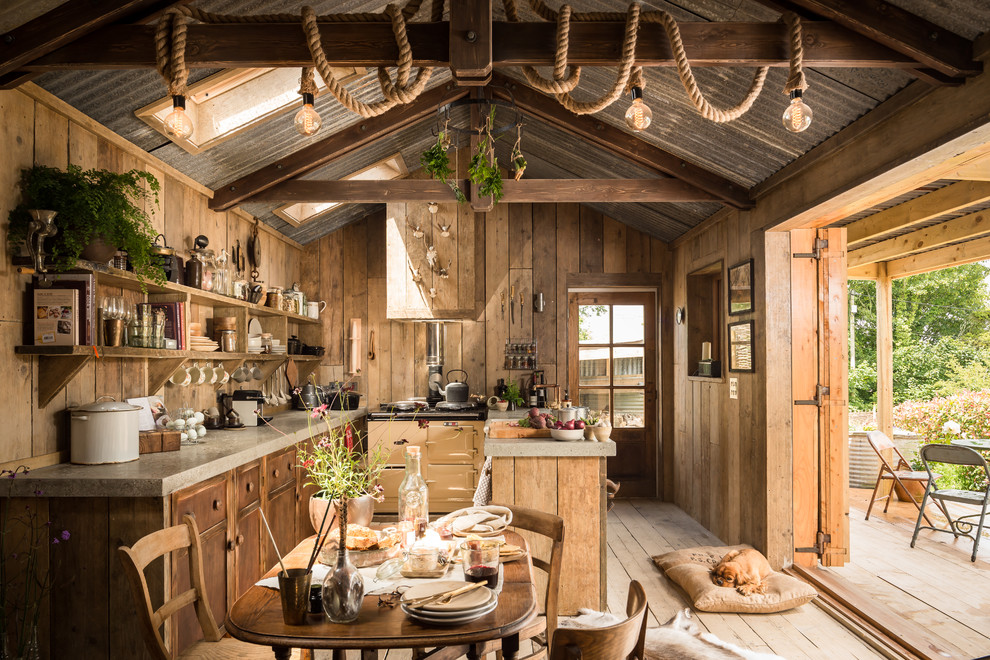 Immagine di una sala da pranzo aperta verso la cucina rustica con parquet chiaro
