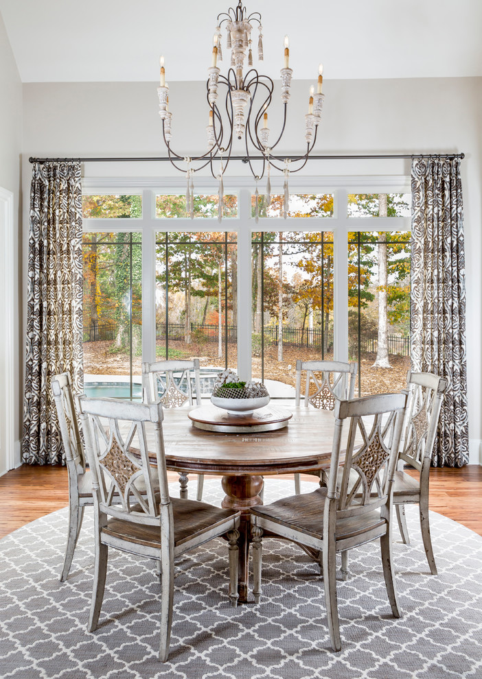 Photo of a traditional enclosed dining room in Charlotte with white walls, medium hardwood flooring and brown floors.