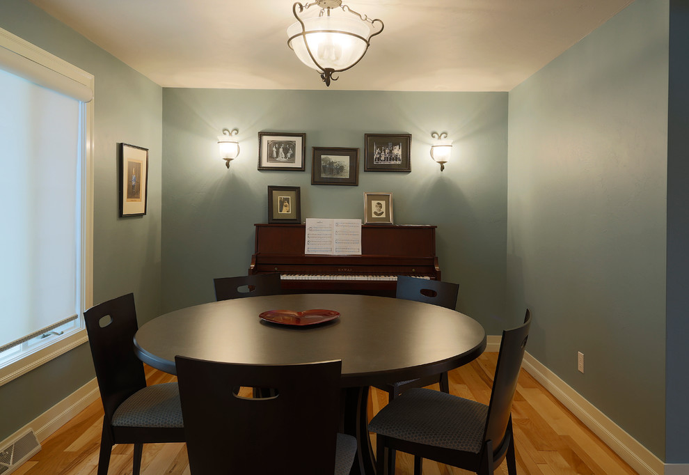 Foto di una piccola sala da pranzo aperta verso la cucina country con pareti blu, parquet chiaro e nessun camino